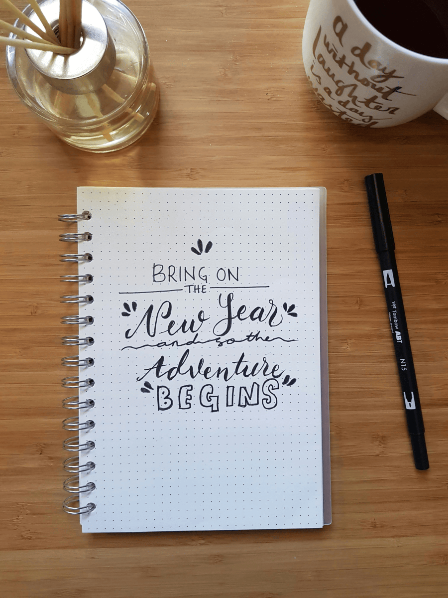 Looking down at a note pad which has a message on it that reads 'Bring on the New Year, and so the adventure begins'