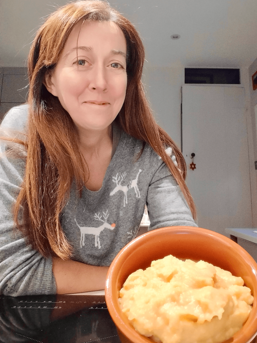 Challenge Fifty-Two, a white woman with dark hair smiling at the camera as she holds a dish of pease pudding towards the camera