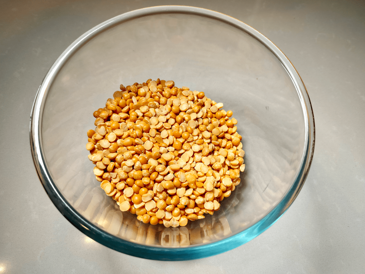 Looking down into a glass bowl at a portion of dried yellow split peas