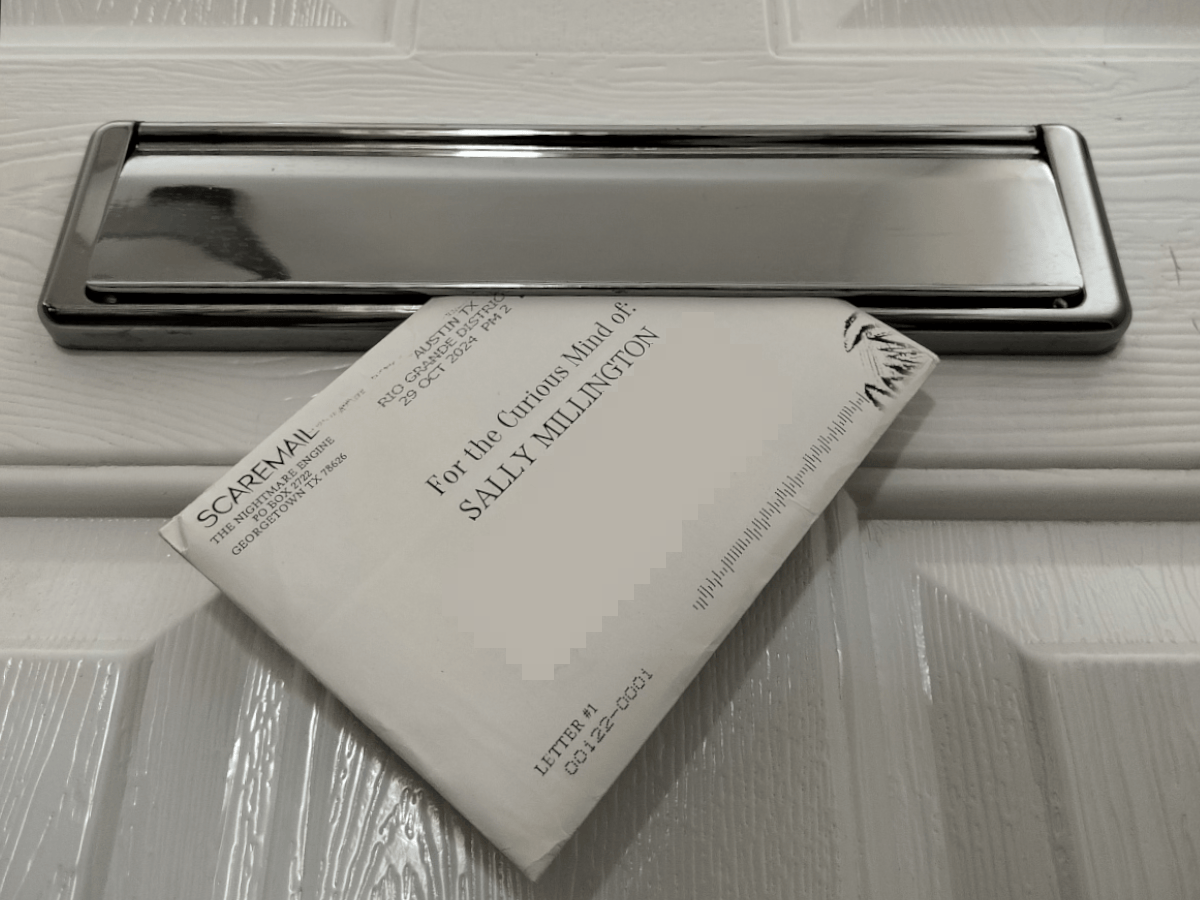 A white envelope through a letterbox in a front door. The envelope reads... 'for the curious mind of Sally' This is the Scaremail horror subscription service