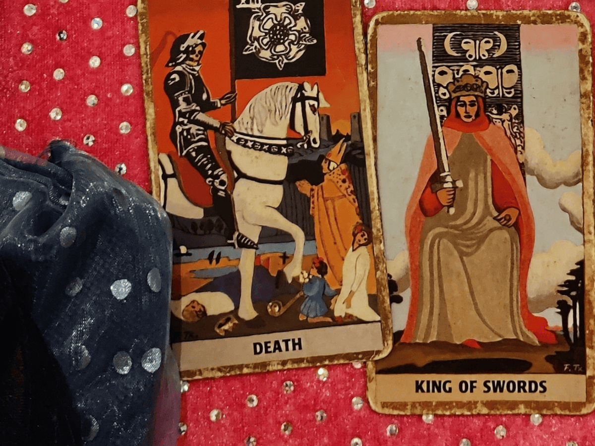 Two tarot cards on a tablecloth