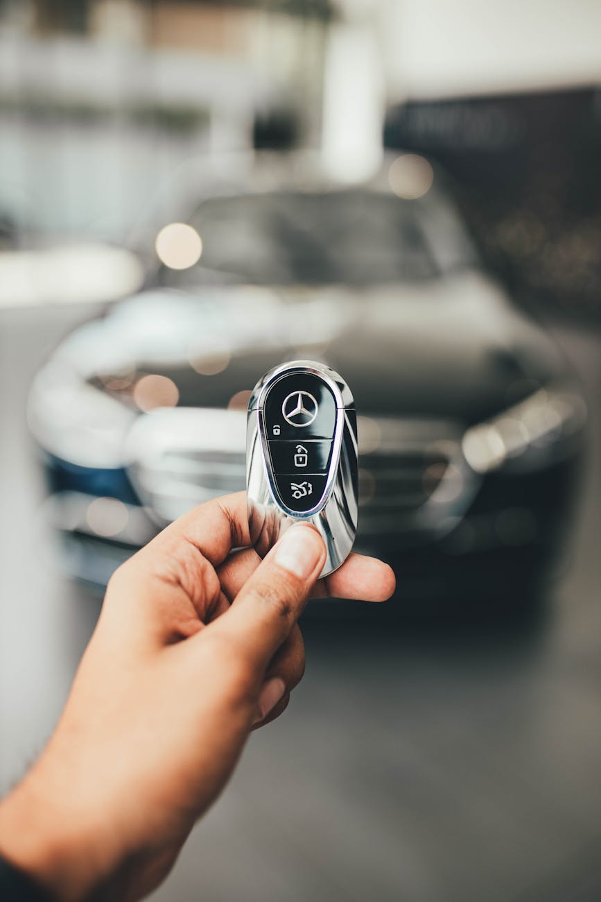 man hand holding new mercedes car key