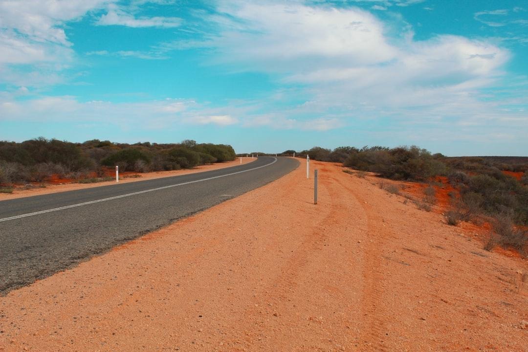 An empty two lane highway running through dry open countryside in Australia