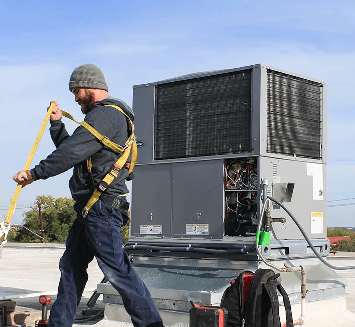 HVAC technician performing rooftop air conditioning repair in New Braunfels.