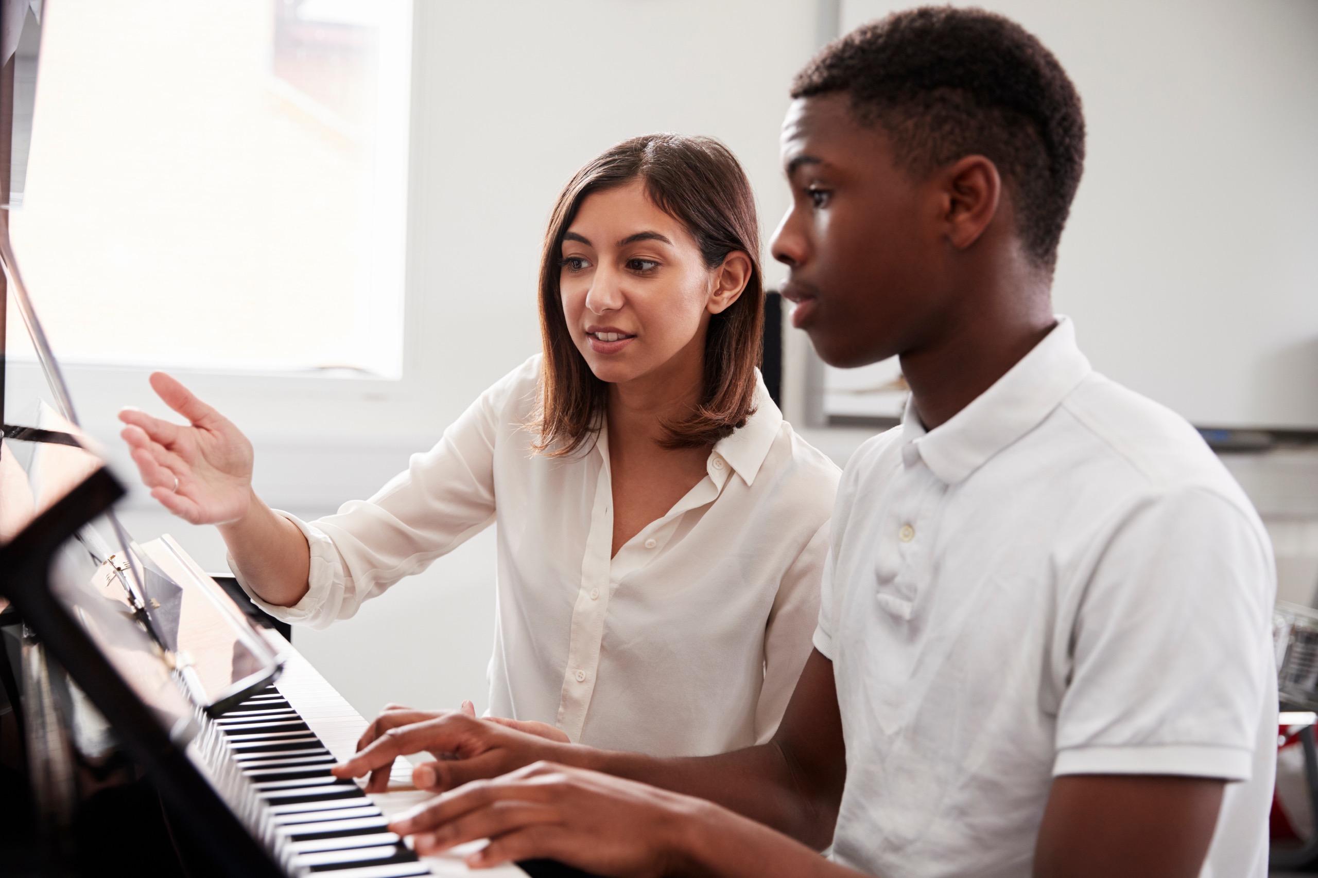A young person at a piano lesson