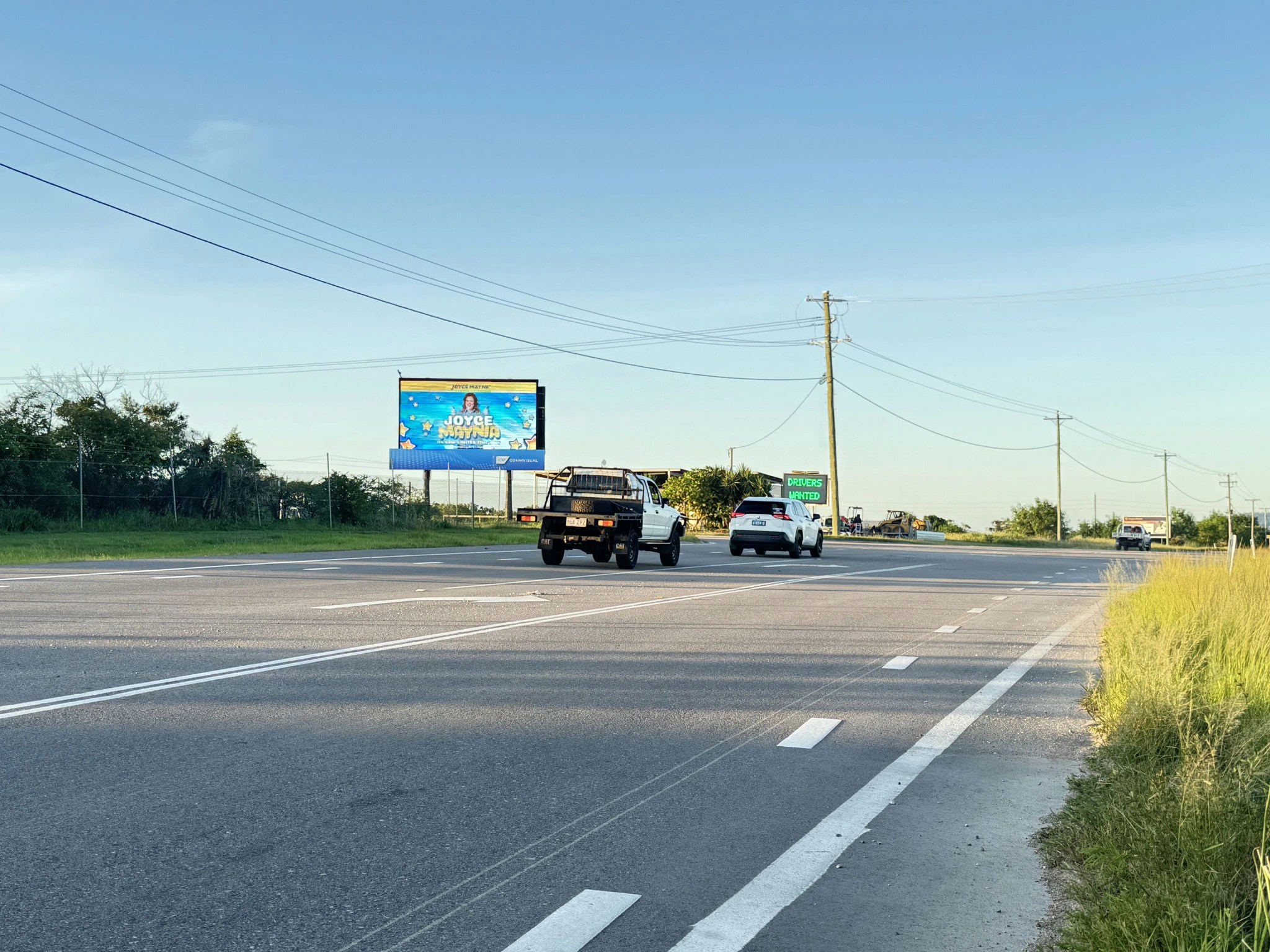 Highway scene with a digital billboard advertising 'Joyce Platinum Cars' and vehicles driving by