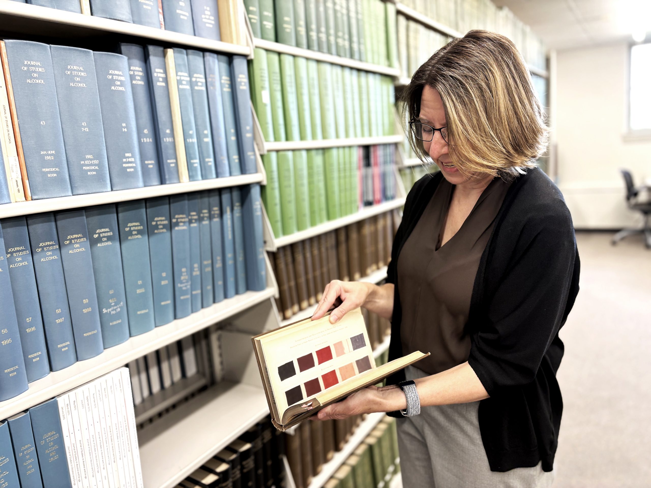 Mary Kate Donais, an analytical chemist and professor at Saint Anselm College, shows the fabric samples found in the first edition of the Journal of the American Cehmical Society, deep in the basement of the college library. Sept. 24,2026
