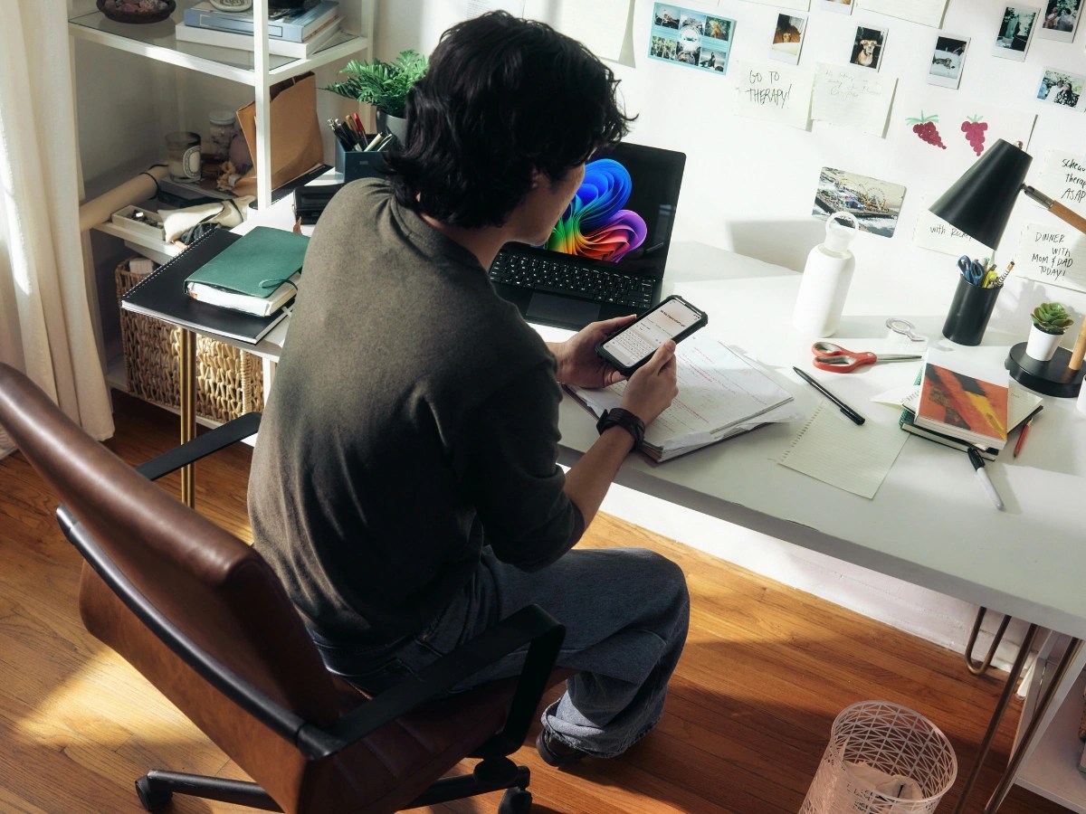 Person using a smartphone while working at a desk