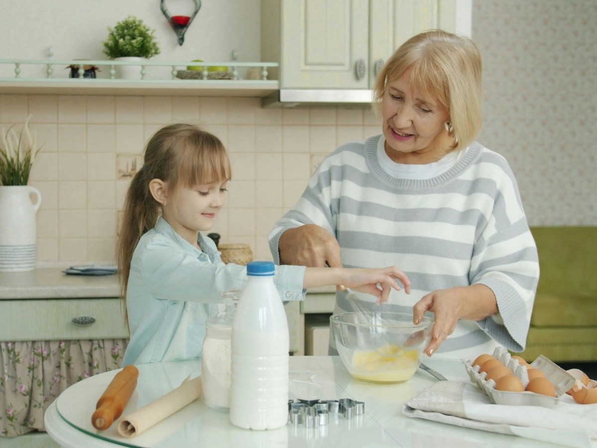 Grandmother and granddaughter baking together in a home kitchen