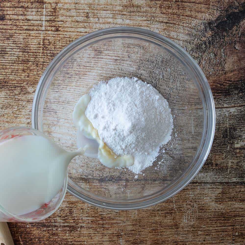 milk poured into mixing bowl with pudding mix