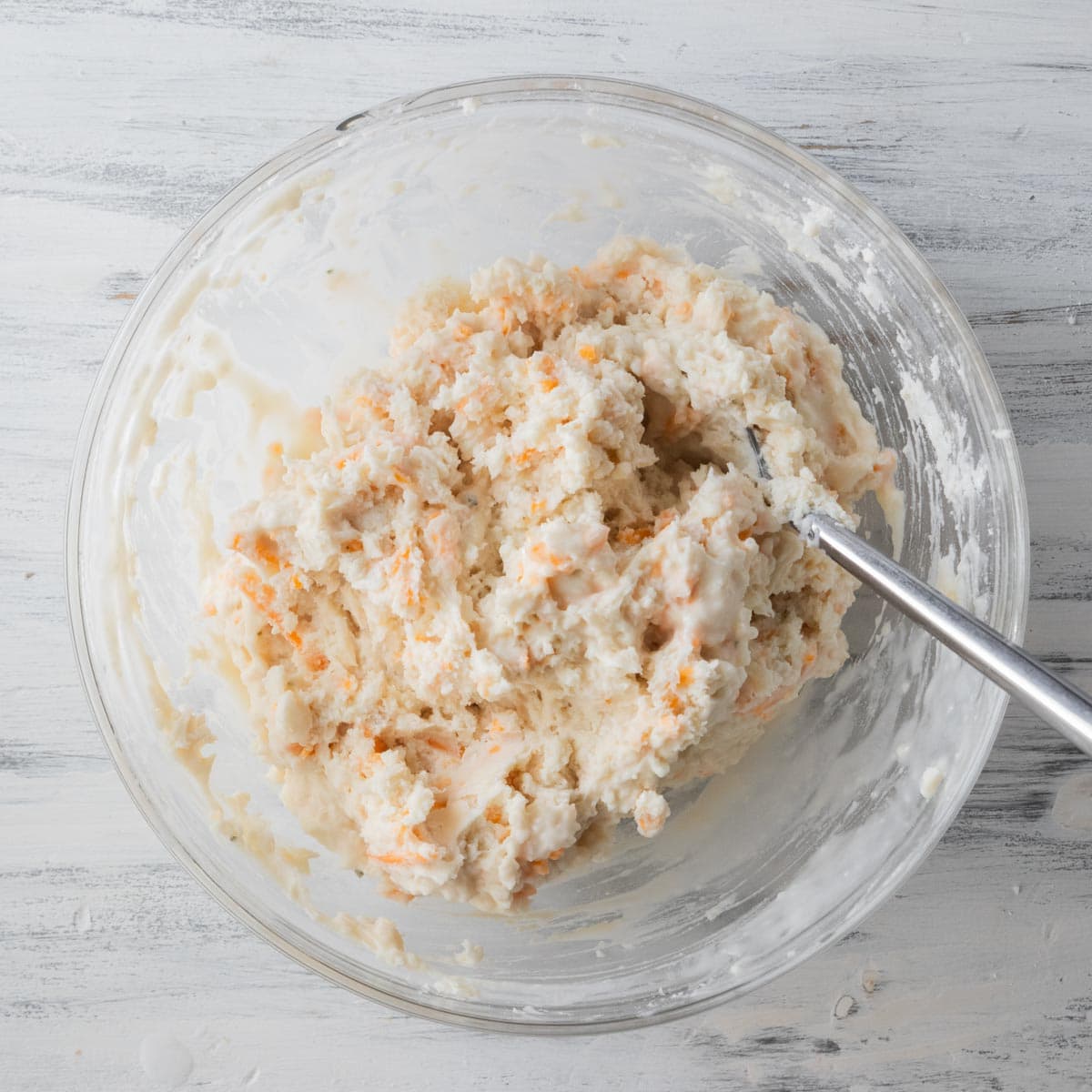 red lobster biscuit mixture in mixing bowl with a spoon