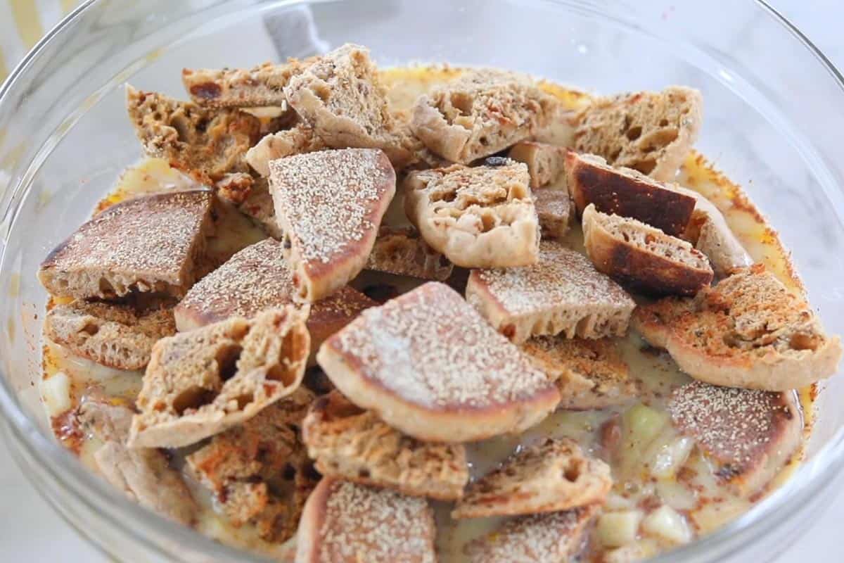 gluten free English muffins soaking in an egg mixture