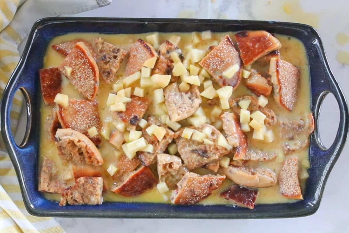 ingredients for apple bread pudding mixed together in baking dish