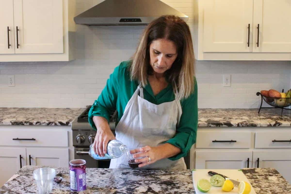jodi of create kids club pouring sparkling water into a cup for mocktails