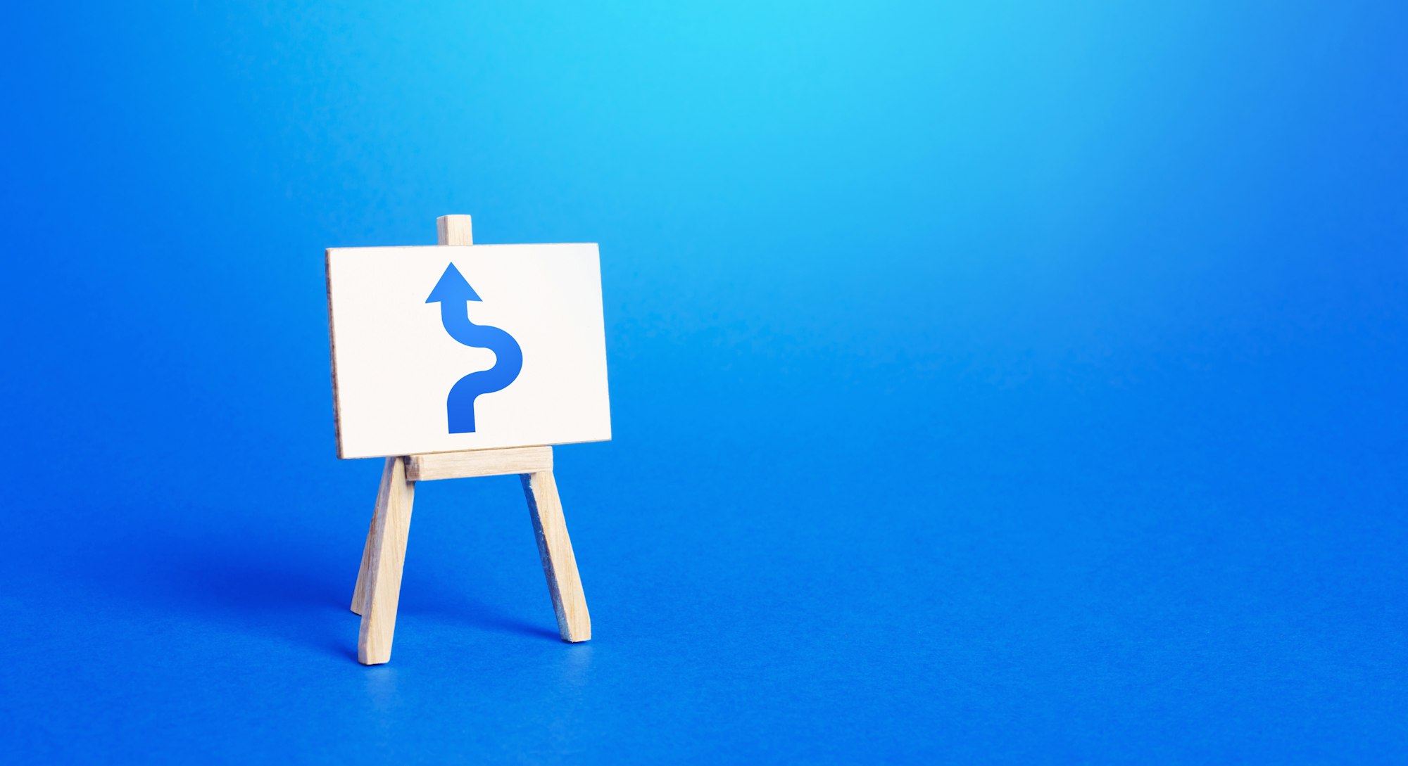 An easel with a blue arrow avoiding an obstacle. Maneuvering, taking right action. Deviation from th