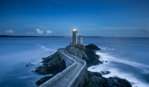 light house at night with a bridge