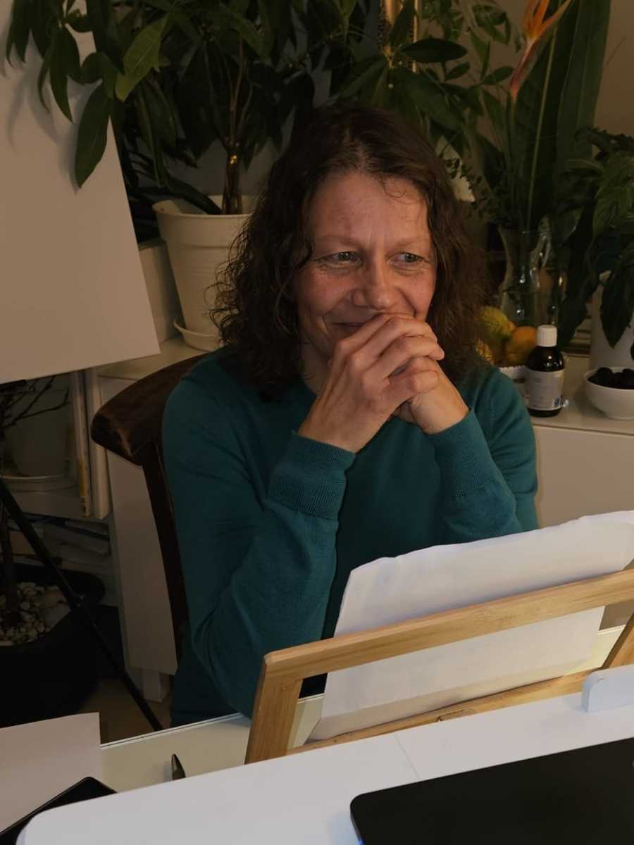 female in front of computer smiling\