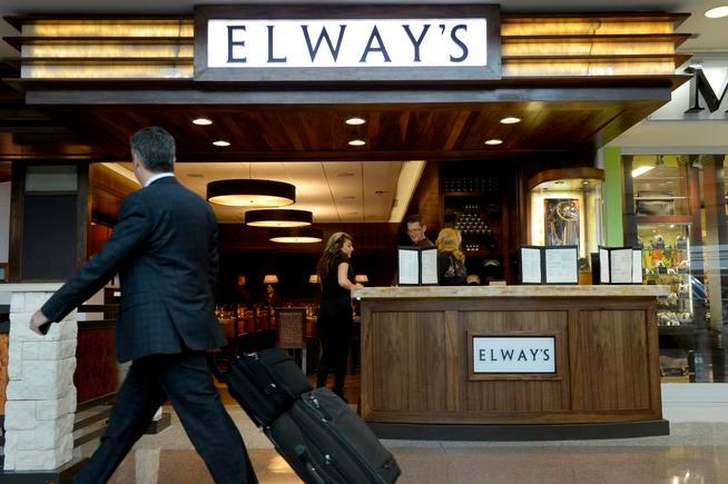 A traveler passes Elway's restaurant at DIA.