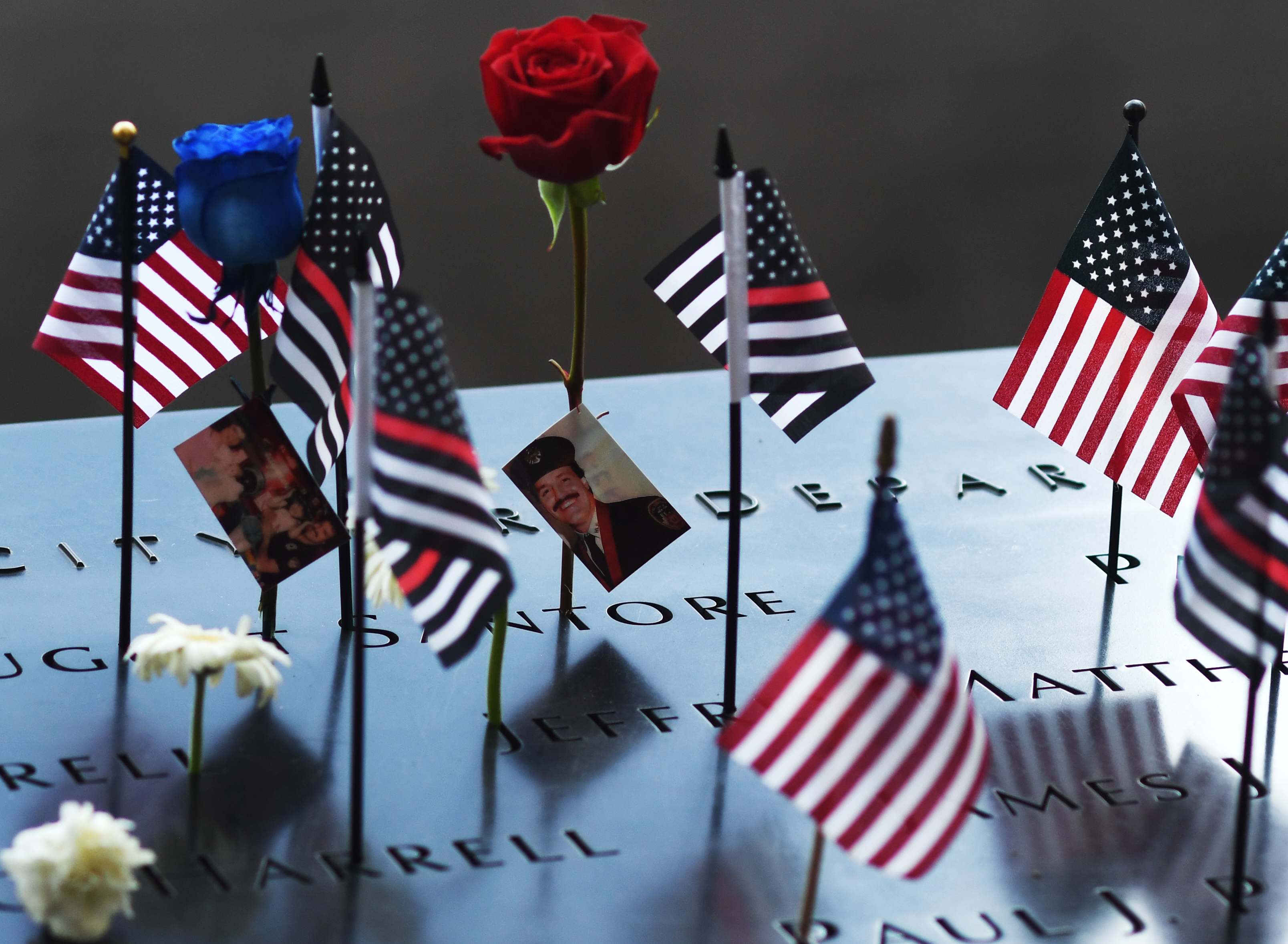 MANHATTAN, NEW YORK - AUGUST 11: Family members leave flowers, flags, and photos at the National 9/11 Memorial and Museum after the ceremony marking the 20th anniversary of the 9/11 attacks on the World Trade Center on September 11, 2021 in Manhattan, New York. (Photo by RJ Sangosti/The Denver Post)