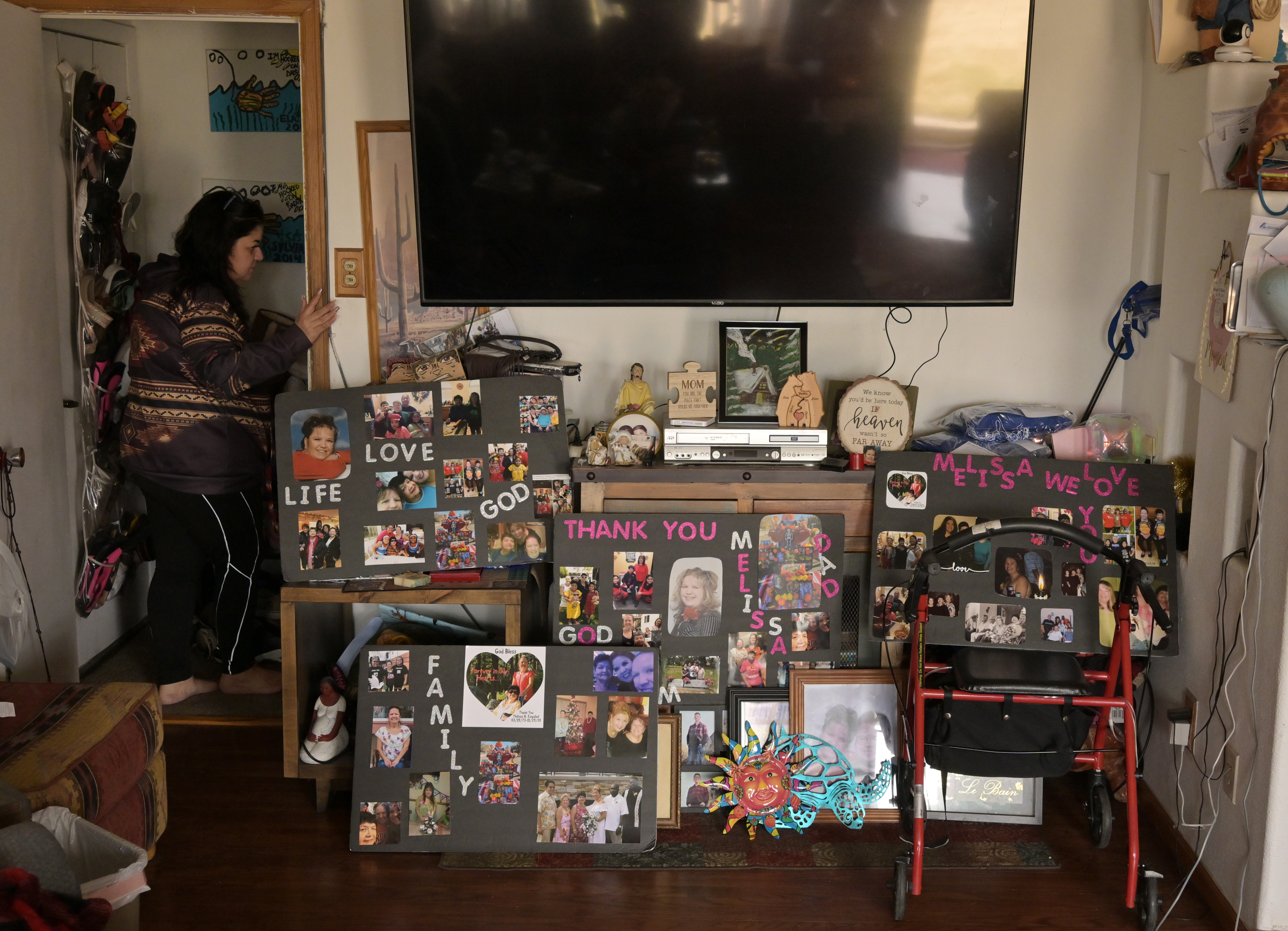 Bernie Esquibel-Tennant heads downstairs at her home in Pueblo, Colorado, on March 19, 2025. Esquibel-Tennant's family kept the posters they made to celebrate her sister, Melissa Esquibel's, life. (Photo by RJ Sangosti/The Denver Post)