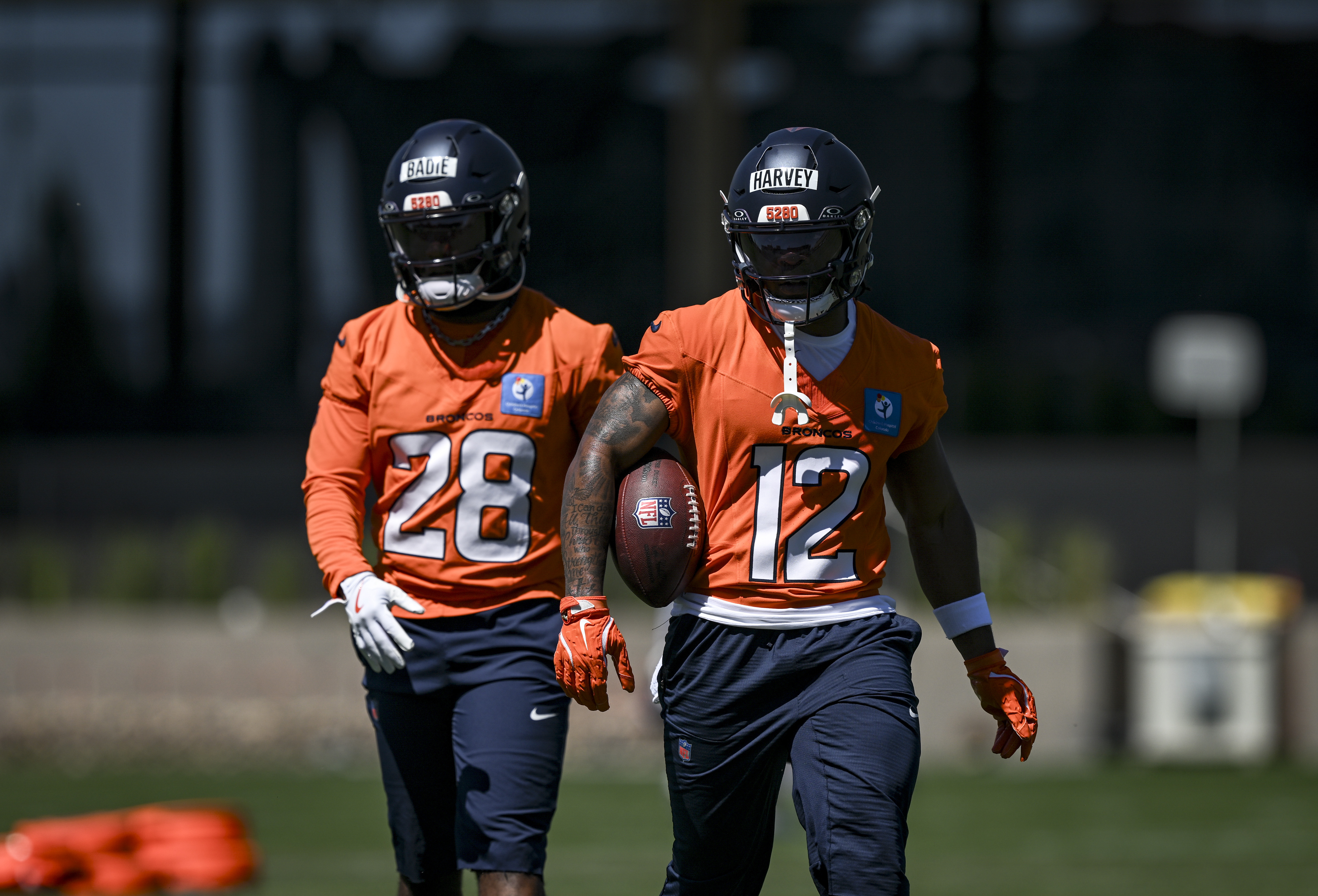 Tyler Badie (28) and RJ Harvey (12) of the Denver Broncos work out with teammates during OTAs at the Broncos Park in Centennial, Colorado on Thursday, June 4, 2026. (Photo by AAron Ontiveroz/The Denver Post)