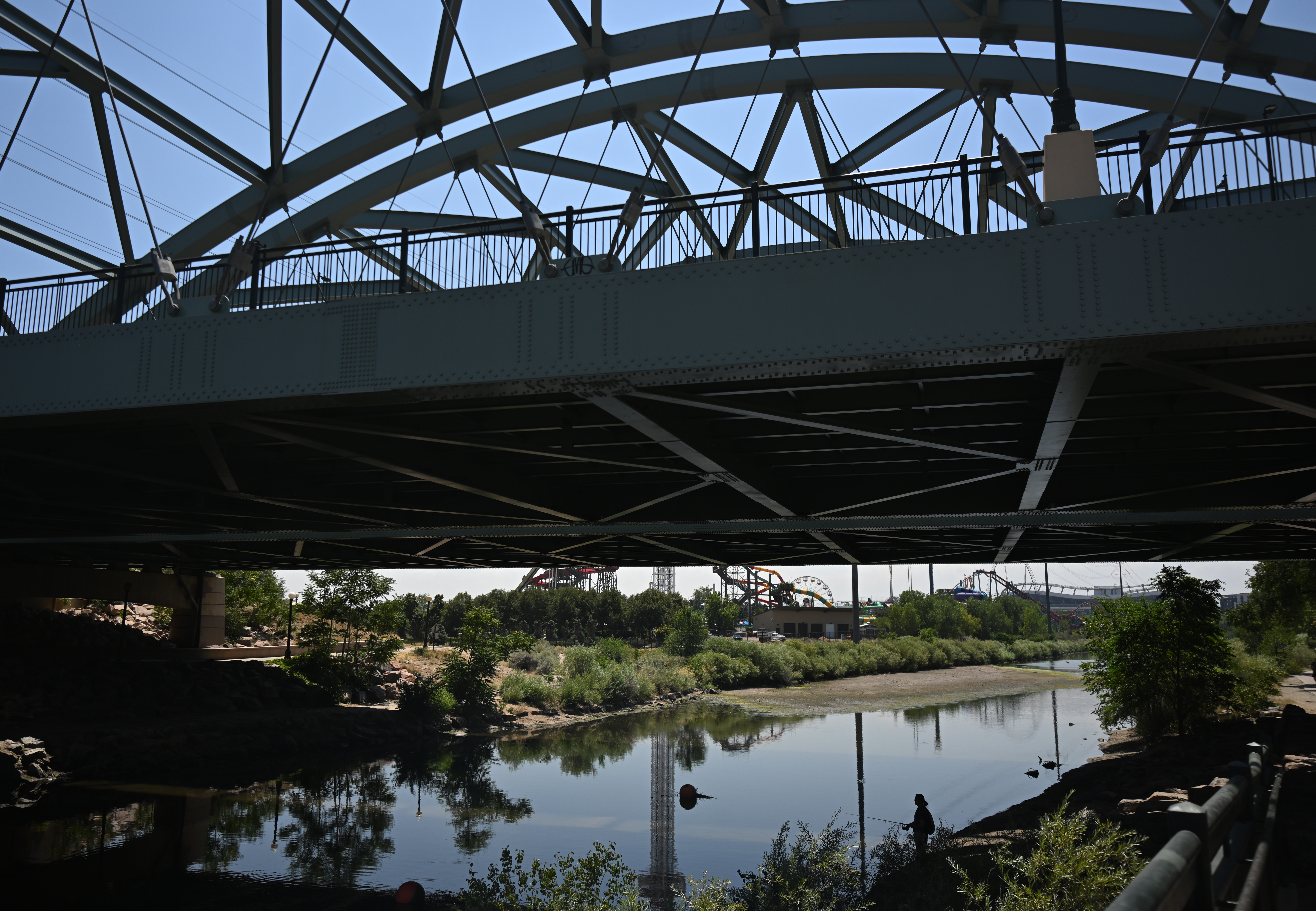 A man fishes beneath a bridge along the South Platte River on Tuesday, July 21, 2026, in Denver. The river is running low because of the ongoing drought and record-low snowpack in Colorado's mountains. (Photo by RJ Sangosti/The Denver Post)