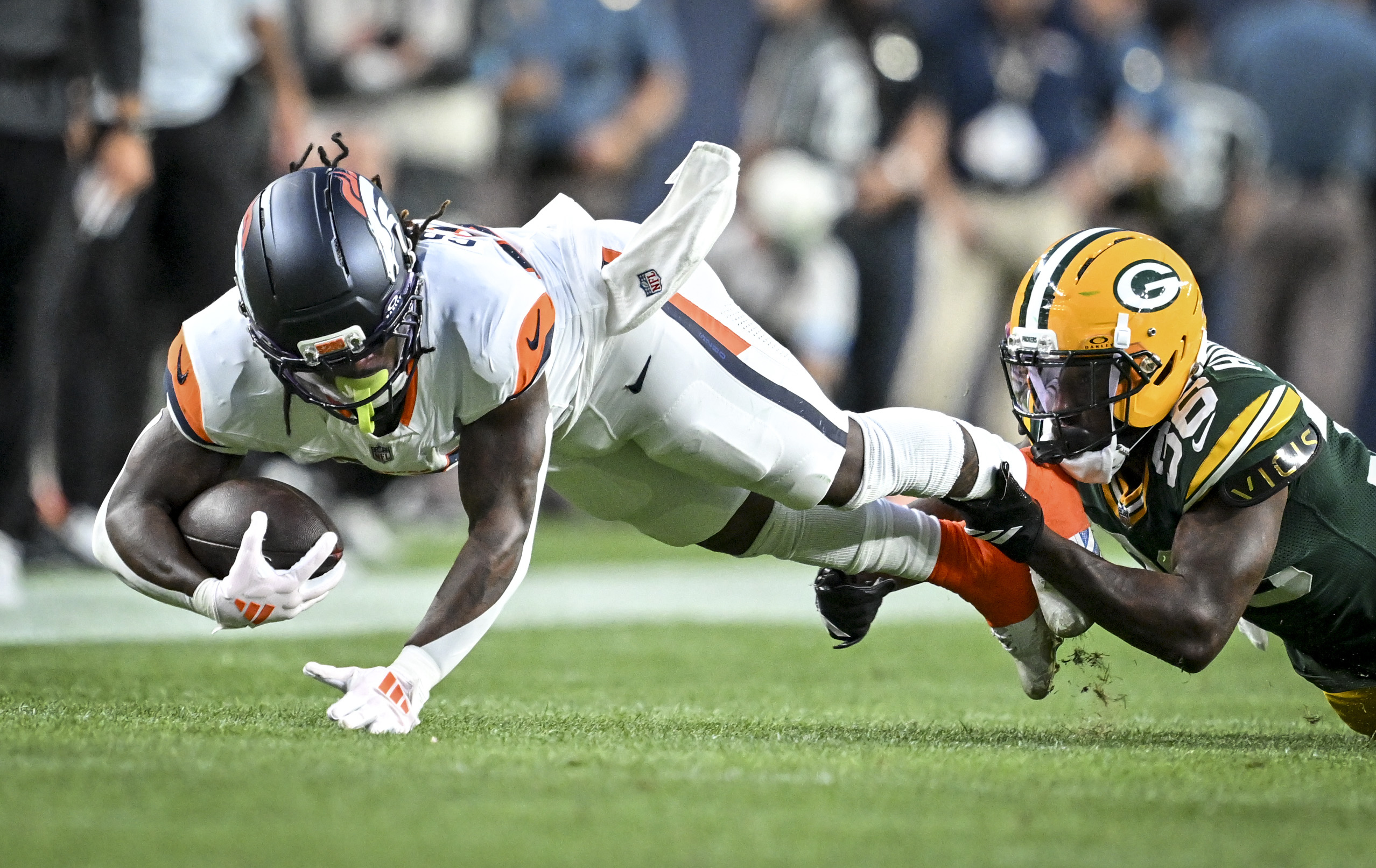 Edgerrin Cooper (56) of the Green Bay Packers tackles Jonah Coleman (20) of the Denver Broncos during the first quarter at Empower Field at Mile High in Denver, Colorado on Friday, August 21, 2026. (Photo by AAron Ontiveroz/The Denver Post)
