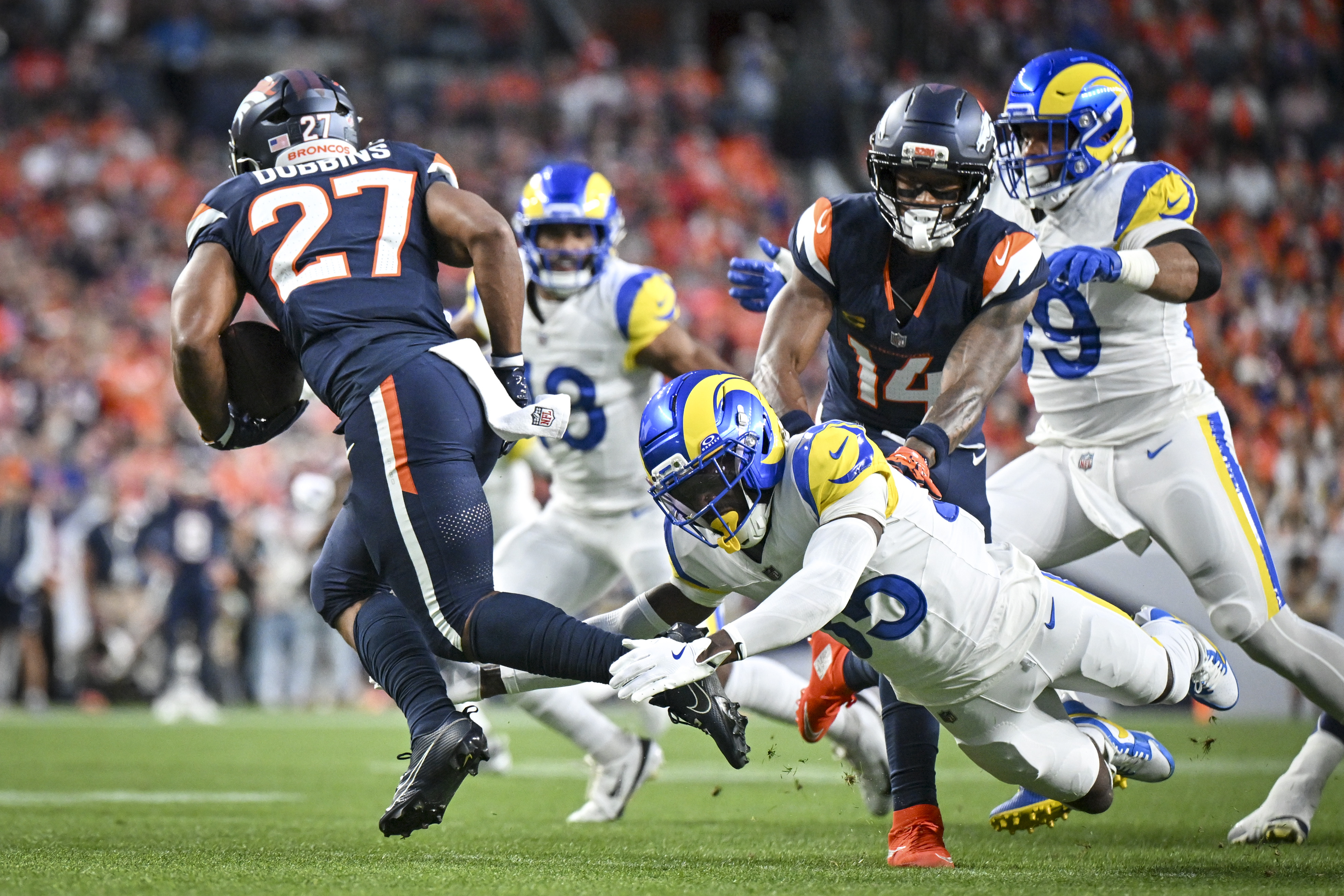 Jaylen Watson (35) of the Los Angeles Rams trips up J.K. Dobbins (27) of the Denver Broncos during the first quarter at Empower Field at Mile High in Denver, Colorado on Sunday, Sept. 27, 2026. (Photo by AAron Ontiveroz/The Denver Post)