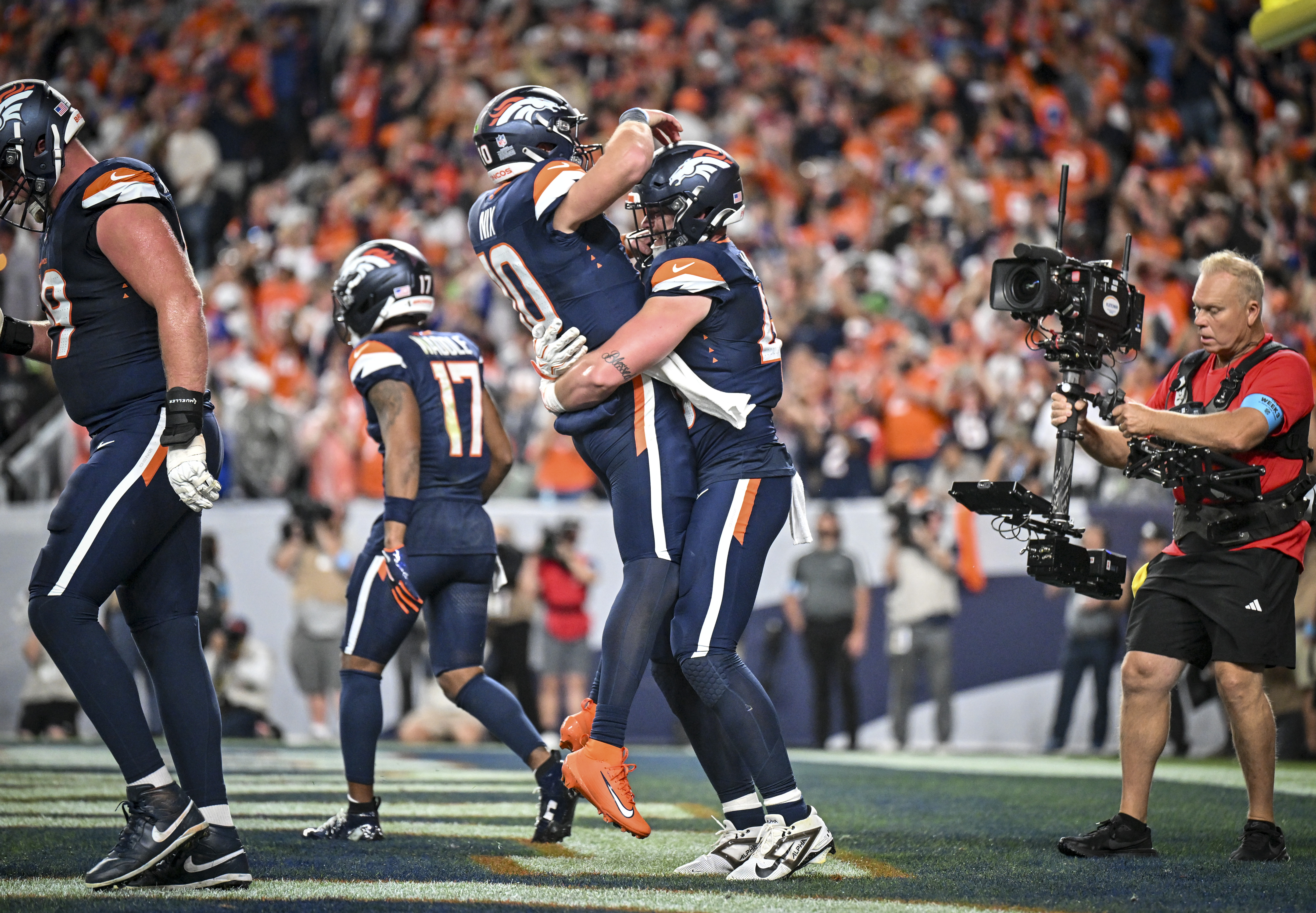 DENVER , CO - SEPTEMBER 27: Nate Adkins (45) of the Denver Broncos celebrates his touchdown by picking up Bo Nix (10) during the third quarter of the Broncos' 30-26 win over the Los Angeles Rams at Empower Field at Mile High in Denver, Colorado on Sunday, September 27, 2026. (Photo by AAron Ontiveroz/The Denver Post)