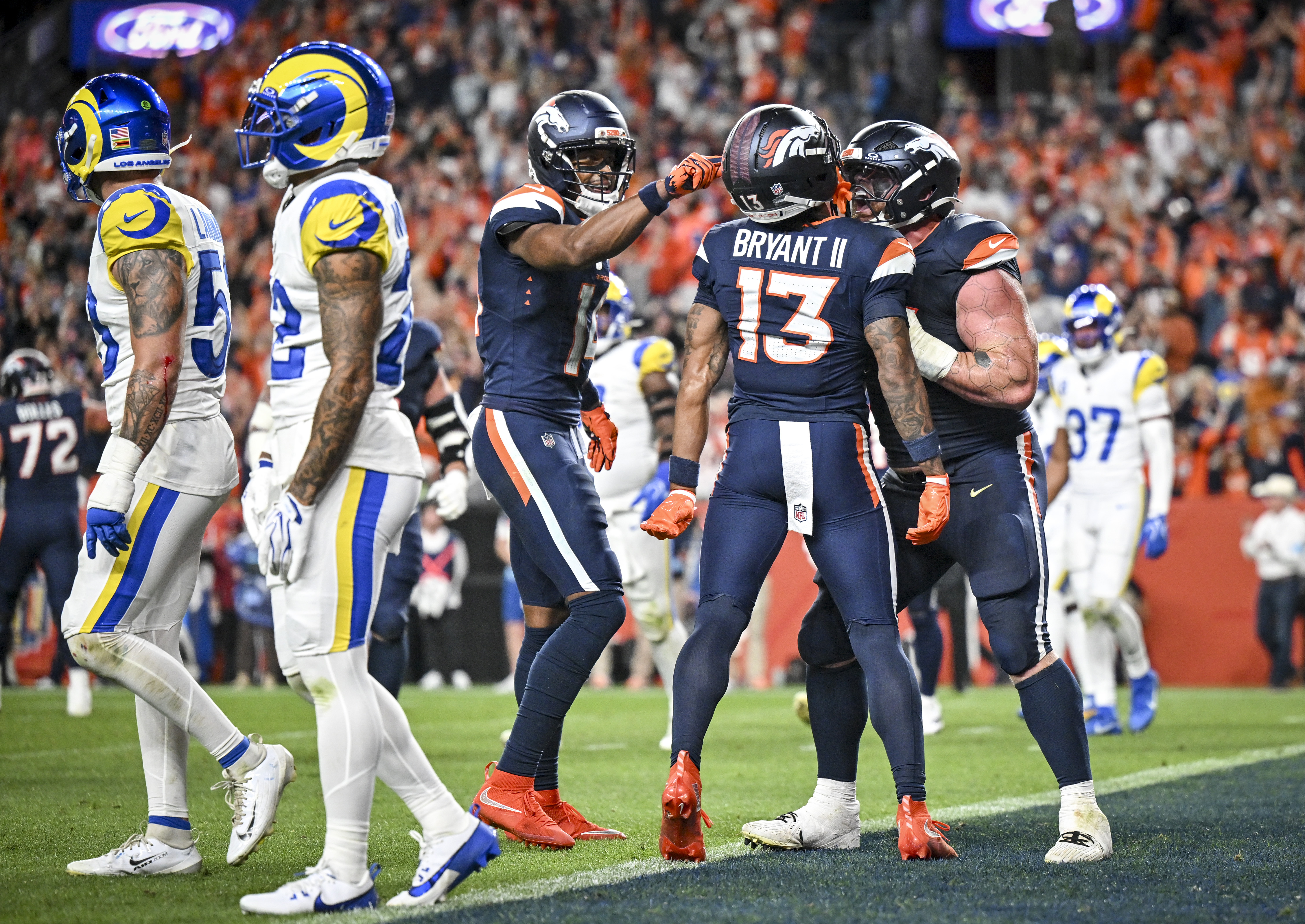 Quinn Meinerz (77) and Courtland Sutton (14) of the Denver Broncos celebrate with Pat Bryant (13) after Bryant snagged a pass for a two-point conversion over Trent McDuffie (22) of the Los Angeles Rams during the third quarter of the Broncos' 30-26 win at Empower Field at Mile High in Denver, Colorado on Sunday, Sept. 27, 2026. (Photo by AAron Ontiveroz/The Denver Post)