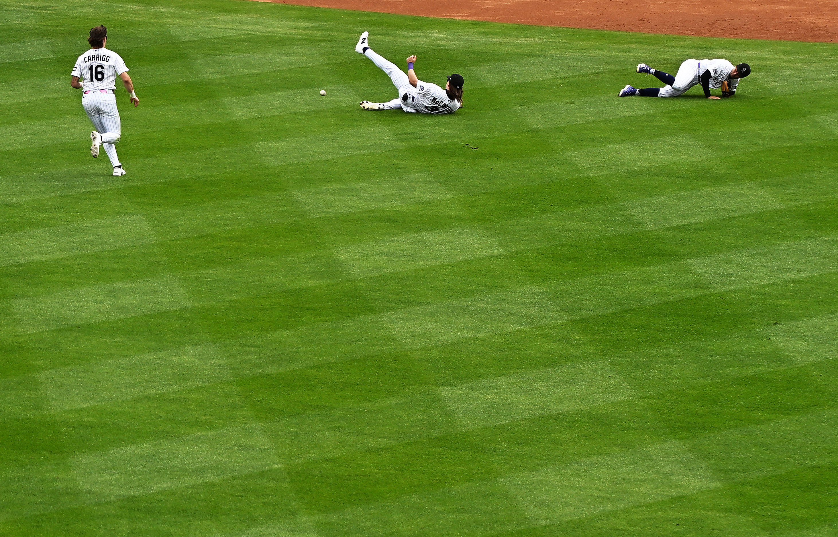 From left, Colorado Rockies center fielder Cole Carrigg (16), left fielder Jake McCarthy (31), center, and shortstop Ezequiel Tovar (14) go after a pop fly ball that dropped in second inning on Thursday, Sept. 24, 2026, in Denver. Colorado Rockies played Arizona Diamondbacks at Coors Field during the Rockies last home game of the season. (Photo by RJ Sangosti/The Denver Post)