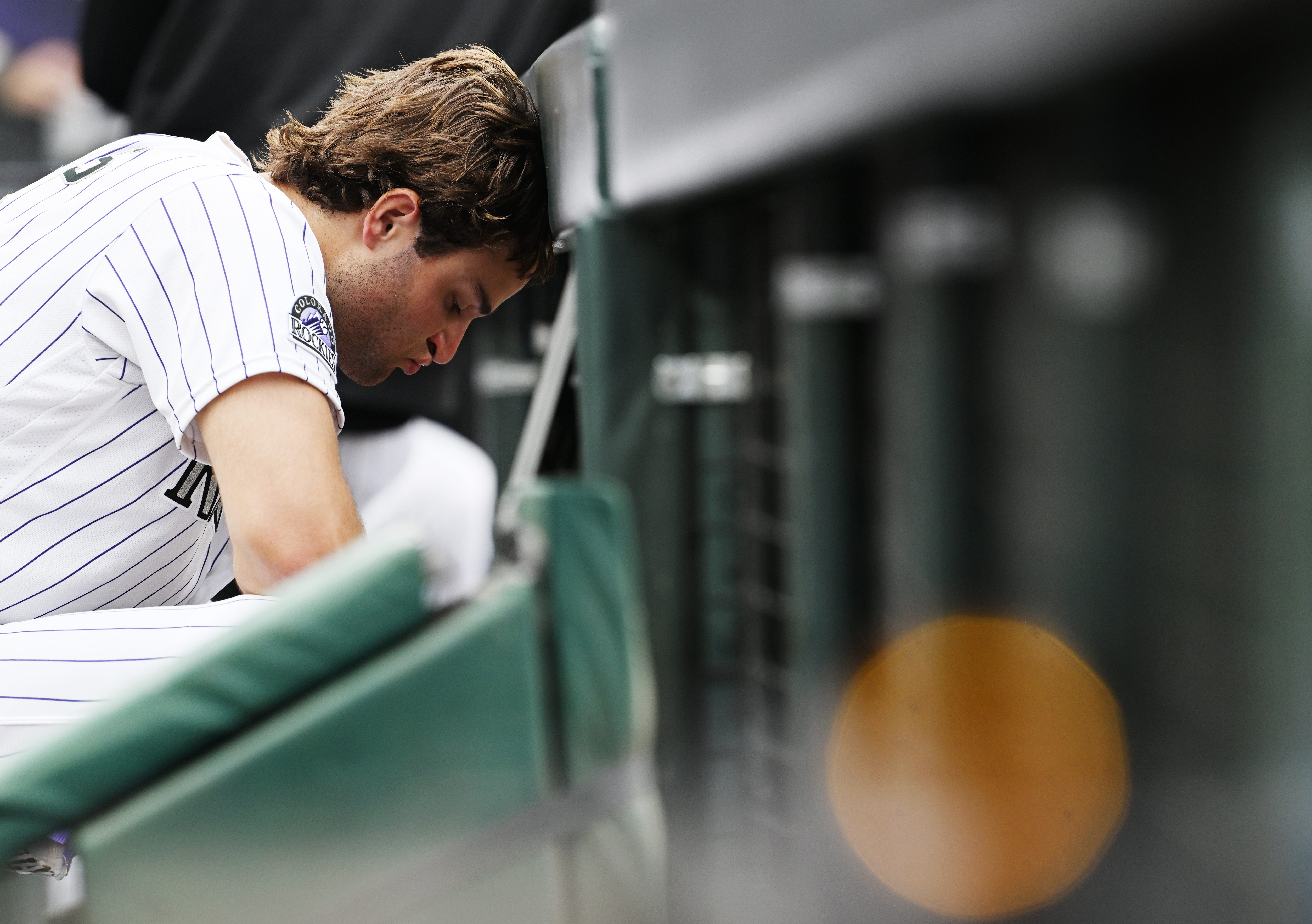 Colorado Rockies third baseman Kyle Karros (12) rests his head against the dugout railing after the Rockies' 12-8 loss to the Arizona Diamondbacks on Thursday, Sept. 24, 2026, at Coors Field in Denver. (Photo by RJ Sangosti/The Denver Post)