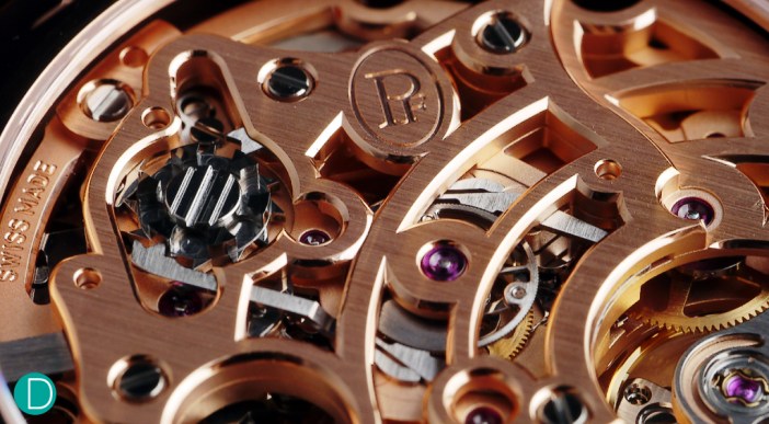 On the left, the split seconds column wheel. In the middle of the photograph is the rattrapante wheel, when braked on command of the column wheel will cause the split hand to stop. The brake mechanism can be also seen in the photograph. A lever presses on the heart cam, on command of the column wheel and is used for the split hand to catch up (rattrapante French word meaning “catch up").