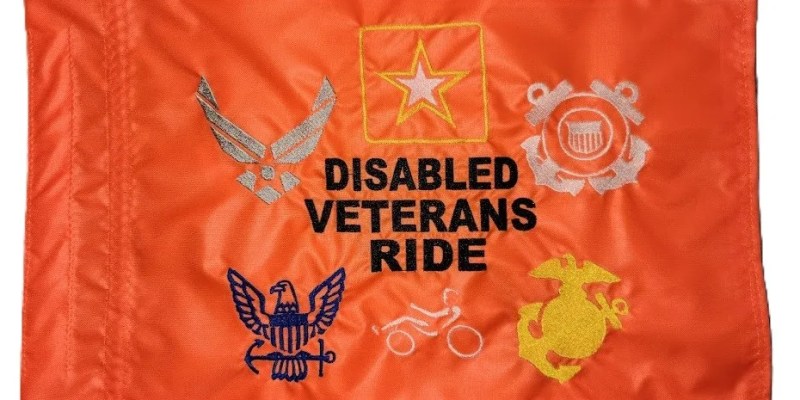 Disabled Veterans Ride safety flag with dense embroidered military branch logos and text on orange nylon rectangle with whip sleeve