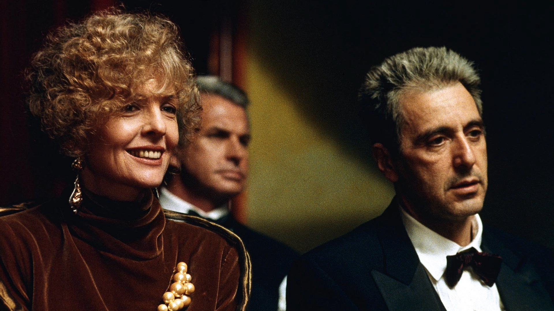 Kay Adams and Michael Corelone sitting next to each other at a party in The Godfather Part III.
