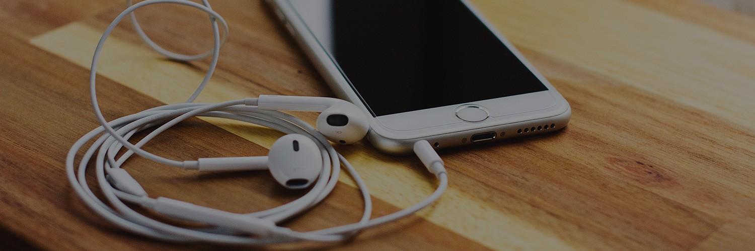 iPod with plugged in headphones resting on a table