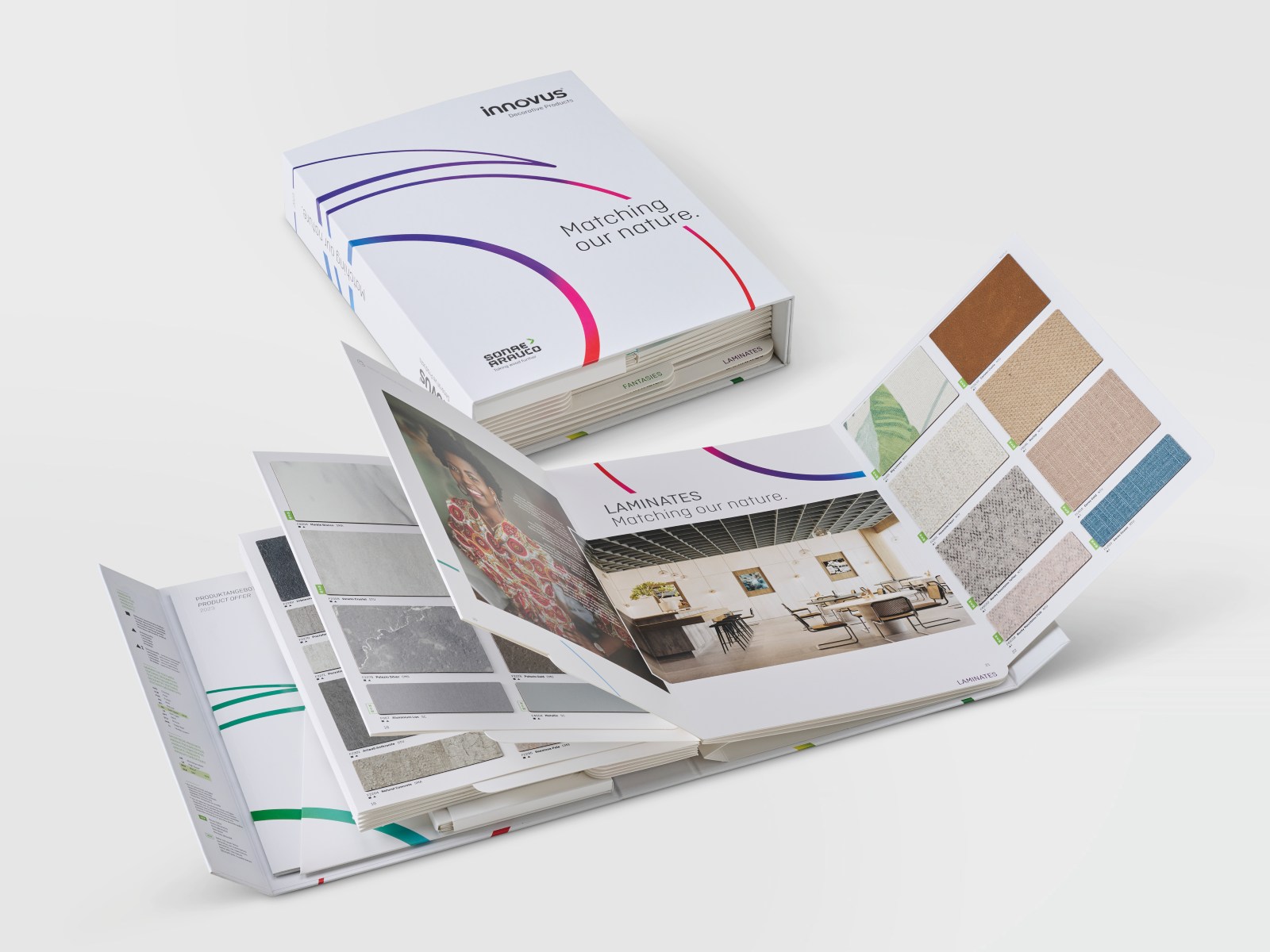 Offener Musterkatalog für Laminatoberflächen mit Farb- und Dekorproben sowie Innenraumbeispielen.