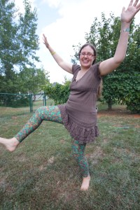 Veronica standing on one leg, holding the other leg an her arms up in the air to show off her colorful LuLa Roe leggings