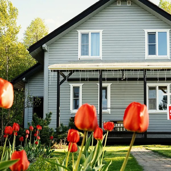 Canada's Spring Housing Market. Gray house for sale with red tulips out front