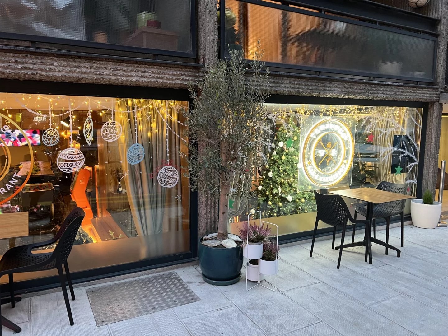 Atmosphère de Fêtes au Restaurant à Genève : Vue extérieure du Toujours+ Lounge Bar Restaurant à Genève avec ses vitrines décorées de motifs de Noël, attirant l'œil des passants et créant une ambiance festive.