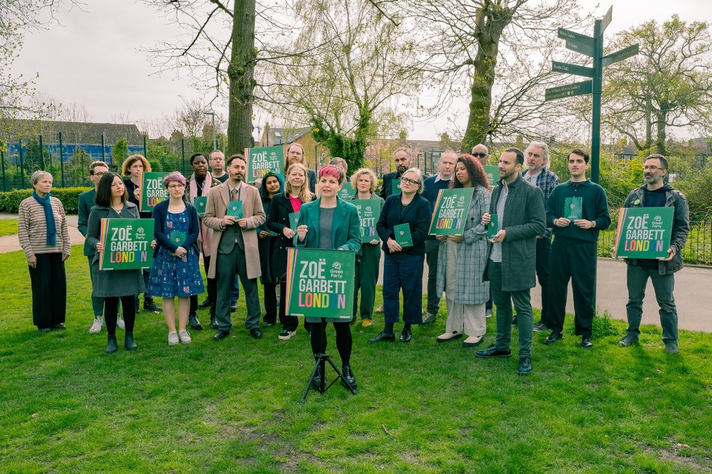 a group of people mainly dressed in green holding placards saying 'ZoeGarbettLondon'