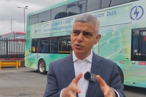 Sadiq Khan talking in front of a green double decker bus