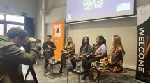 A panel discussion at a Centre for London event, featuring speakers seated with a welcome banner and QR code displayed behind them.