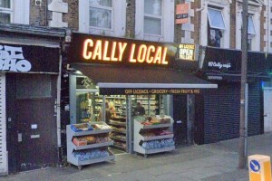 Cally Local storefront displaying bright signage; shelves stocked with groceries and fresh produce outside, showing a bustling urban atmosphere.