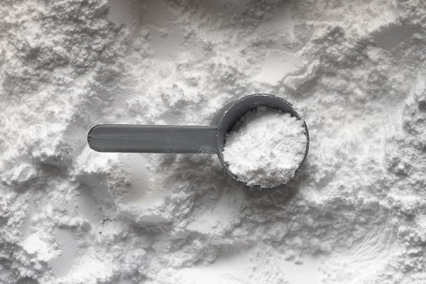 white protein powder for PCOS with a scoop