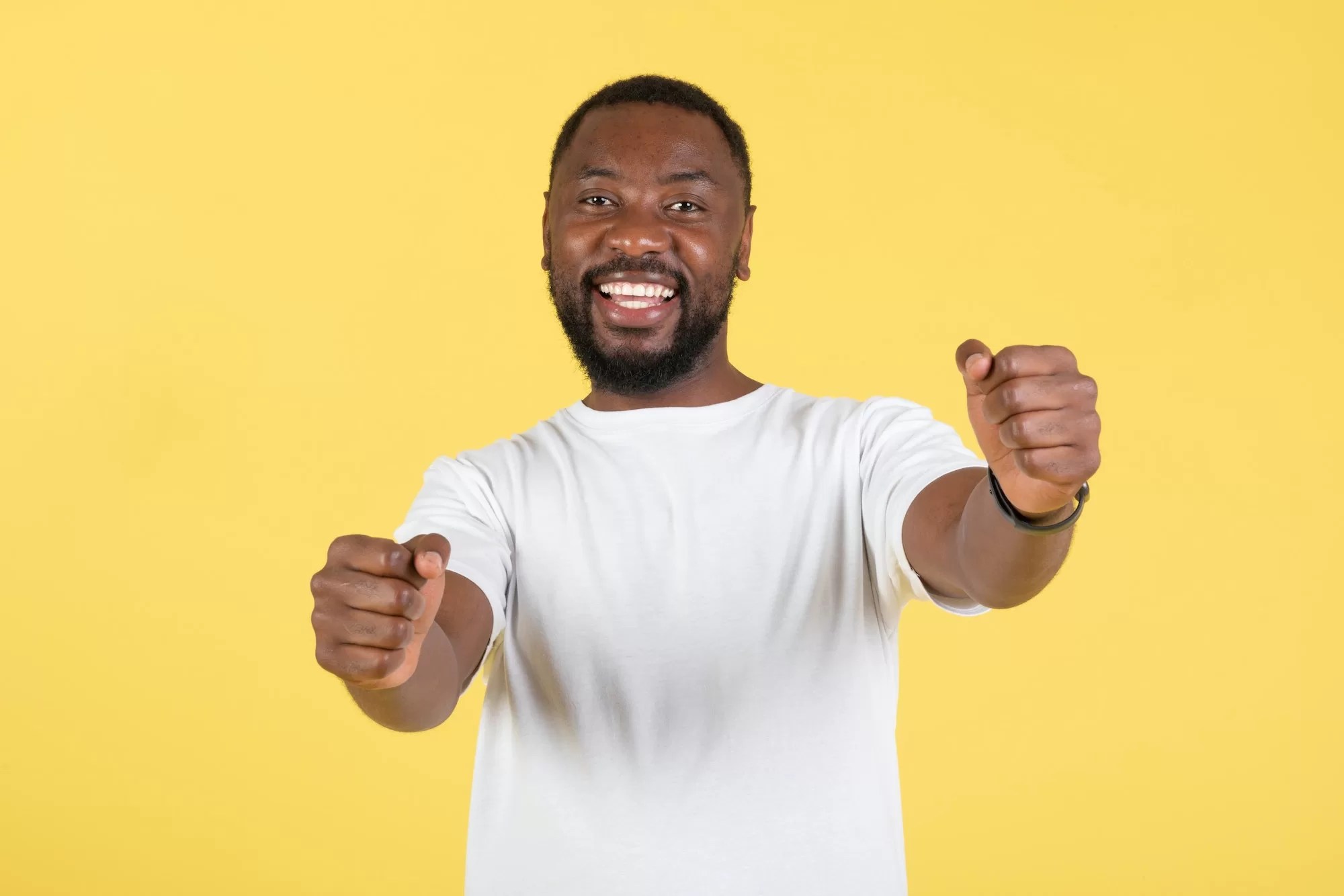 African Guy Holding Invisible Wheel Pretending Driving Car, Yellow Background | NaTIS Driving Test Tips: What Learners Need to Know