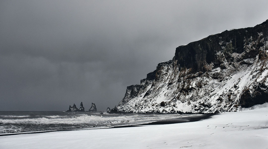 Jsland Reynisdrangar aan het zwarte strand in Vík
