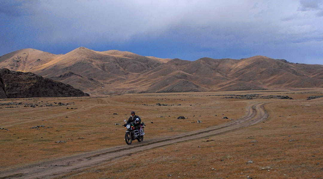 Man op een motor in het plattelandsleven in Mongolië Orkhon Valley NP