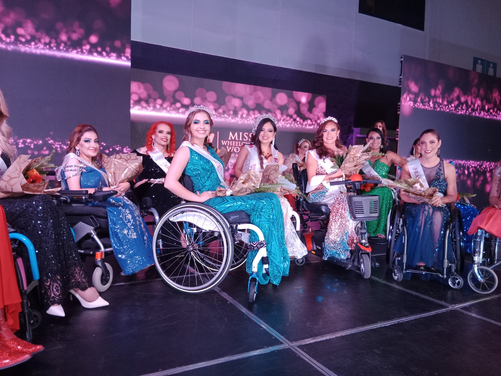 Participantes de Miss Wheelchair World, con sus vestidos de gala en la pasarela.