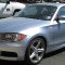 Light blue BMW 135i E82 coupe, front three-quarter view in a parking lot